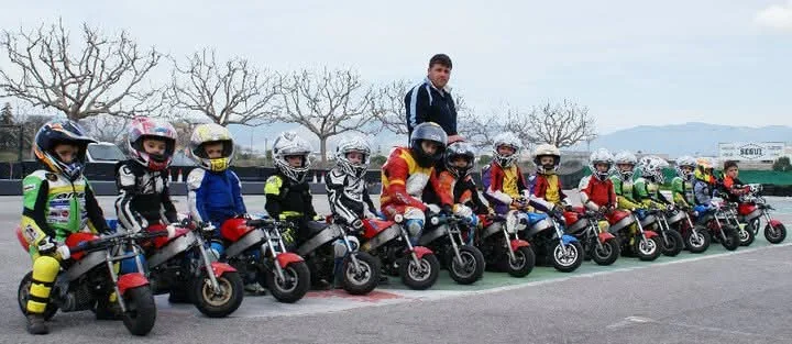Grupo de jóvenes pilotos junto a sus motos
