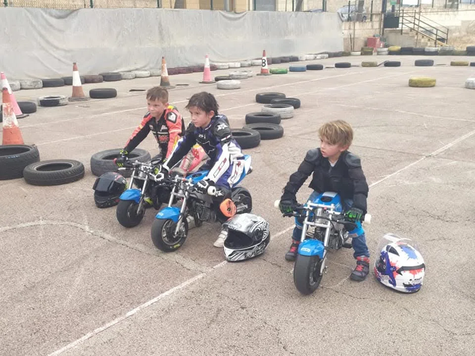 Niños entrenando en minimotos en un circuito