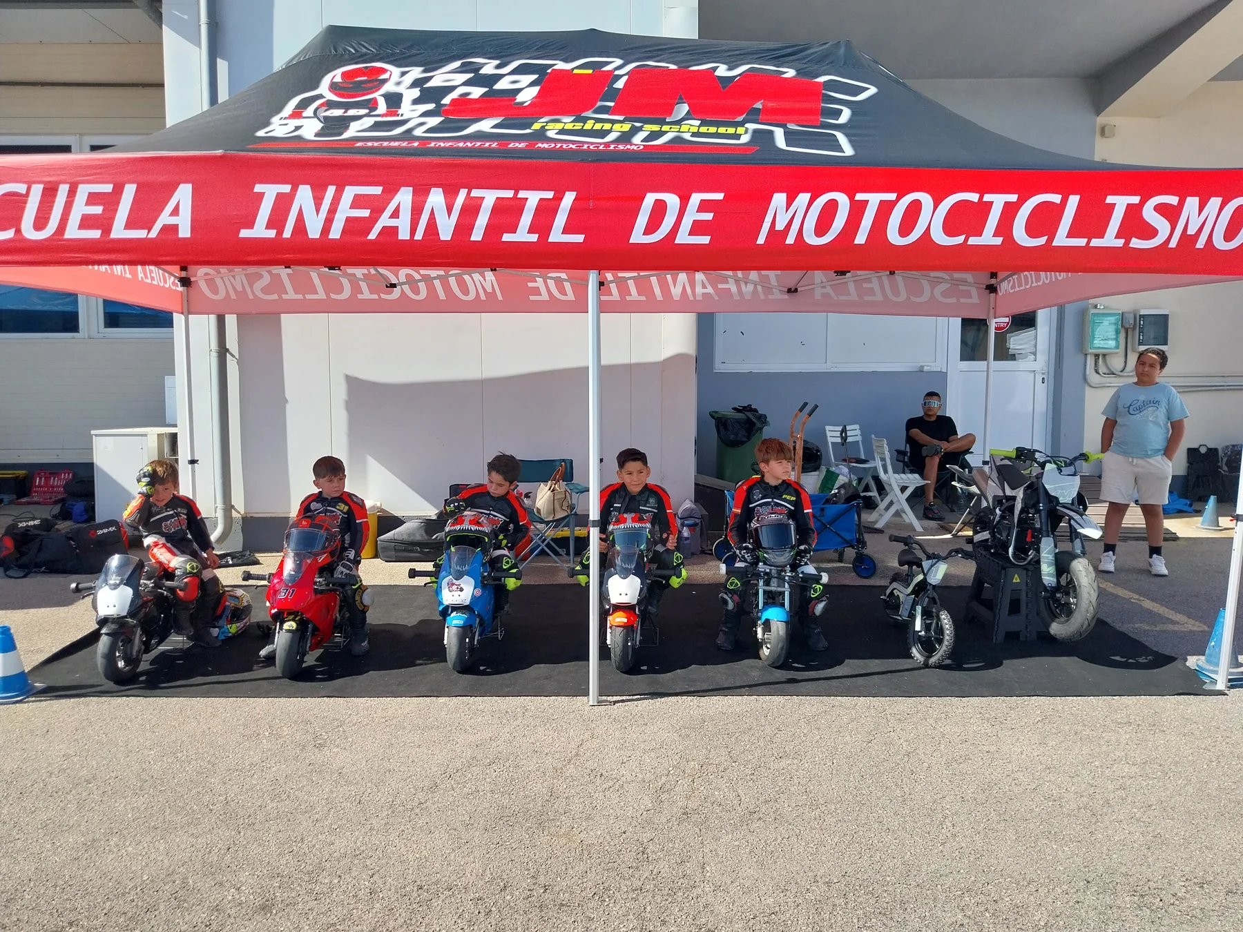 Jóvenes pilotos de velocidad con sus minimotos y equipación junto al equipo de JM Racing School